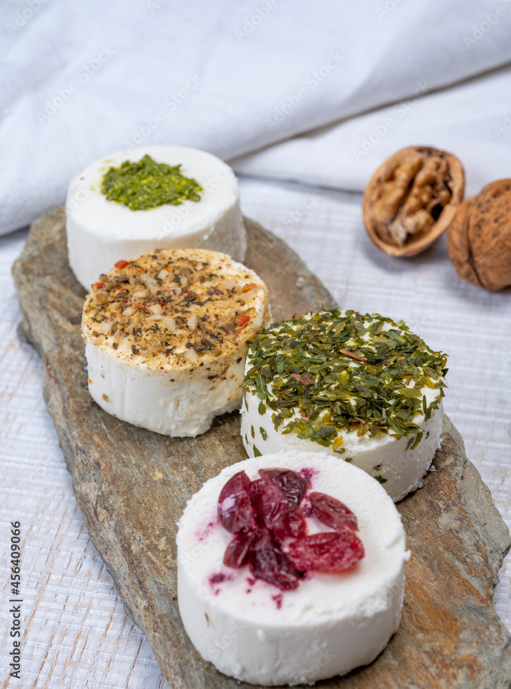 Cheese collection, variety of fresh white soft goat French cheeses with aromatic herbs, berries and green pesto Cheese collection, variety of fresh white soft goat French cheeses with aromatic herbs, berries and green pesto