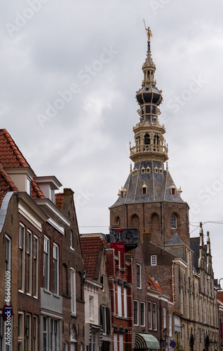 Walking in old Dutch town Zierikzee with old church tower, small houses and streets