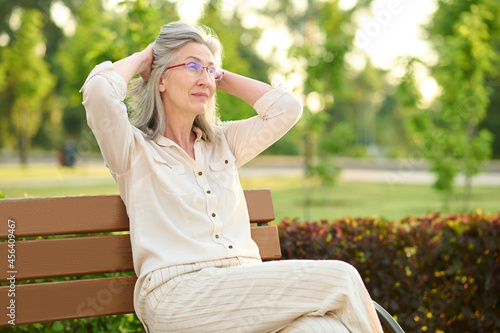 Calm woman resting on park bench
