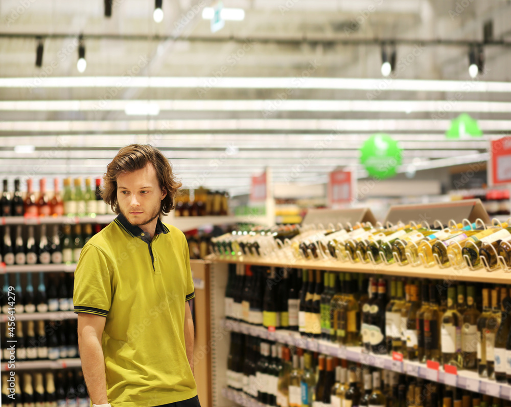 man choosing a wine, champagne at supermarket	