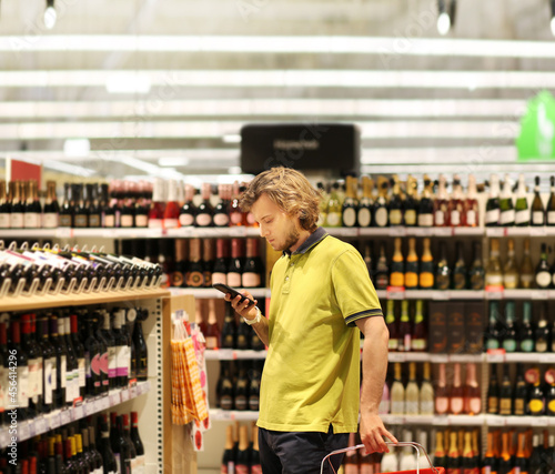 man choosing a wine, champagne at supermarket 