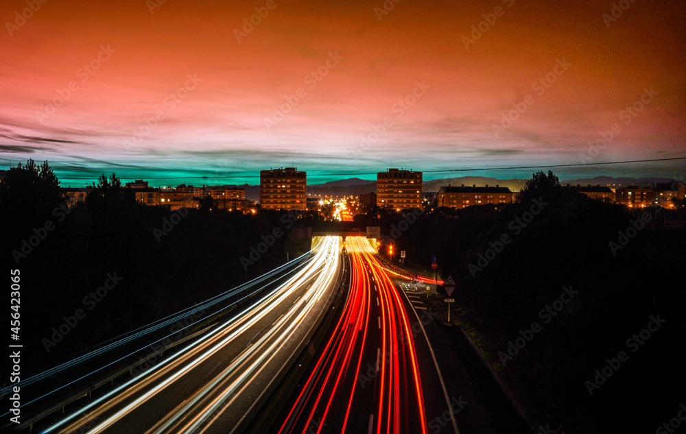 Rayos de luces, en cámara lenta, de coches circulando por autopista de noche para entrar y salir de la ciudad de granollers, barcelona.