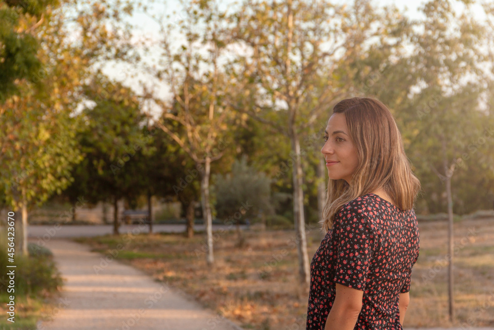 Young woman smiling walking in a park in autumn. Selective focus. Young woman smiling walking in a park in autumn. Selective focus.