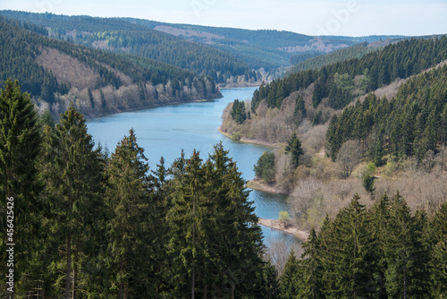 Blick auf eine Talsperre von oben mit Bergen und blauem Wasser