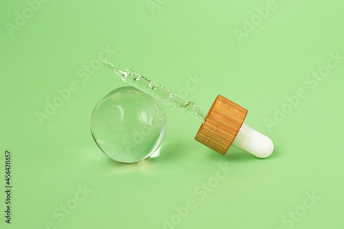 Closeup photography of the pipette with cosmetics gel inside,bubbly sructure.Pastel mint background.Cosmetic mockup concept. photo