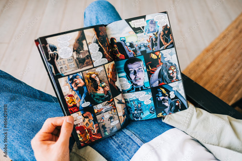 Obraz premium Man reads comic book in living room at home. Rostov-on-Don, Russia. 8 September 2021