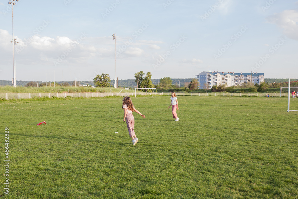 Two little girls fun on green fields