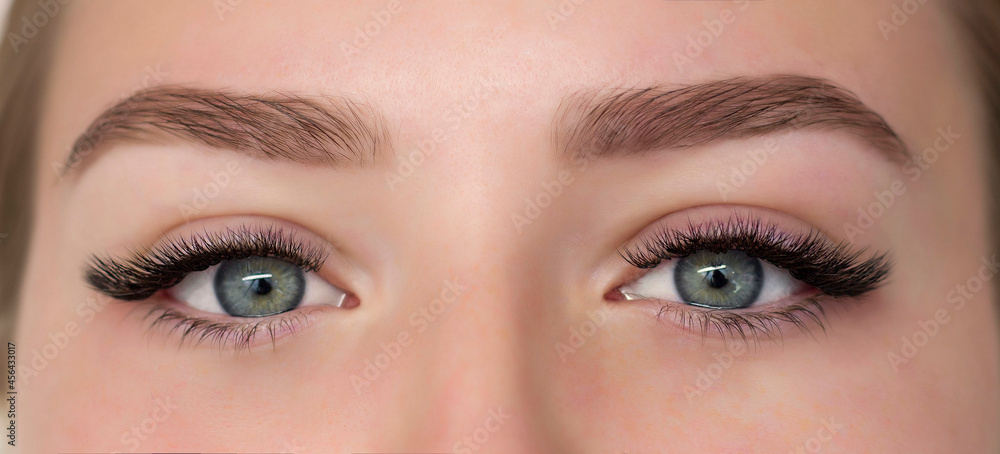 Fototapeta premium A girl with beautiful green eyes painted with black eyelashes. Close-up of the eyes.