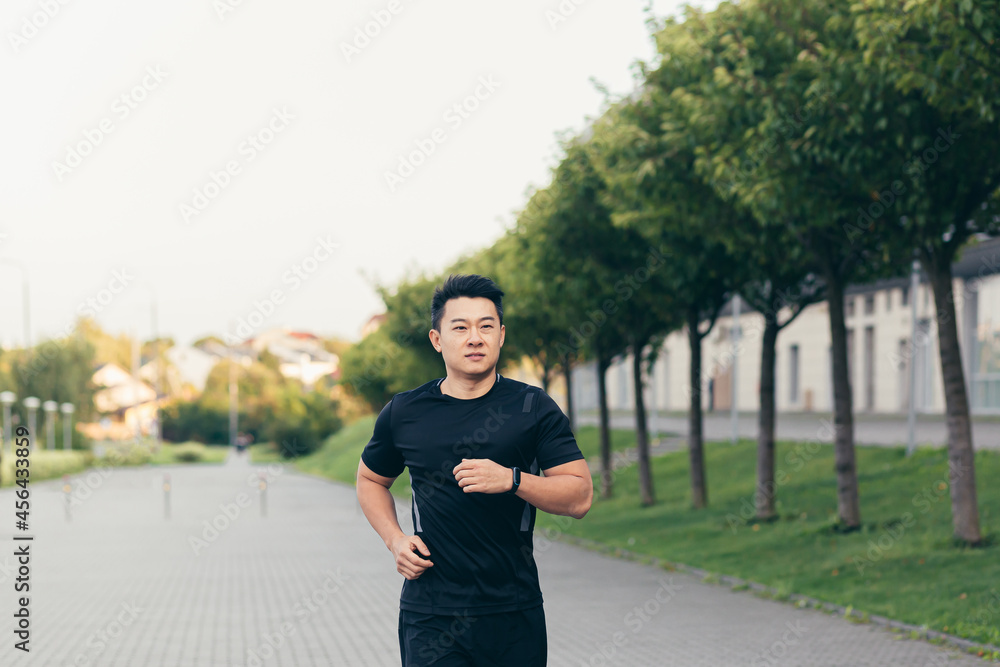 Male asian athlete on a morning run in the park near the stadium