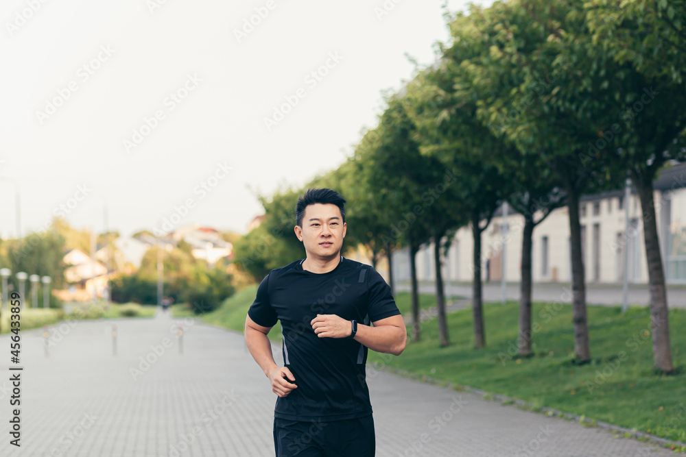 Male asian athlete on a morning run in the park near the stadium Male asian athlete on a morning run in the park near the stadium