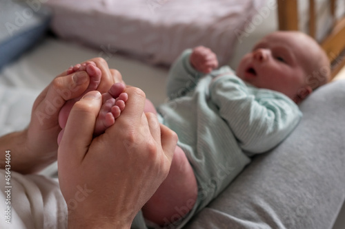 Obraz na plátně Hands holding baby feet checking reflex of a newborn.