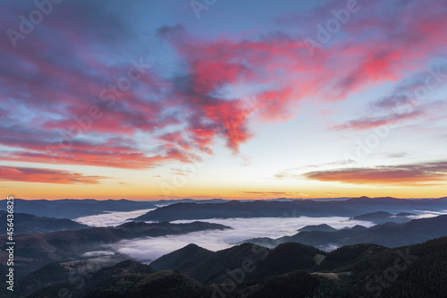 Sunrise on the foggy morning. Landscape with high mountains. Panoramic view. Forest of the pine trees. Touristic place. Natural scenery. Location Carpathian, Ukraine, Europe. Wallpaper background.