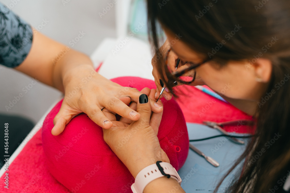 Woman hands doing manicure in salon.