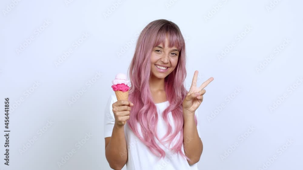holding a cornet ice cream smiling and showing victory sign with a cheerful face over isolated background holding a cornet ice cream smiling and showing victory sign with a cheerful face over isolated background