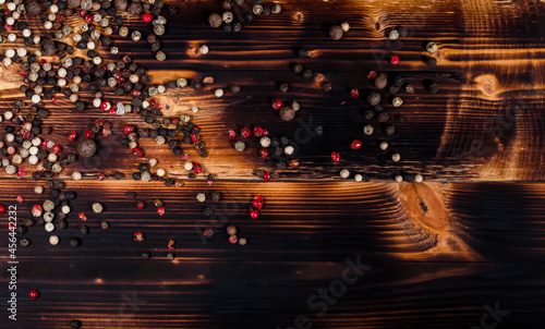 Big red, white and black pepper on a dark wooden table © Lianna Art