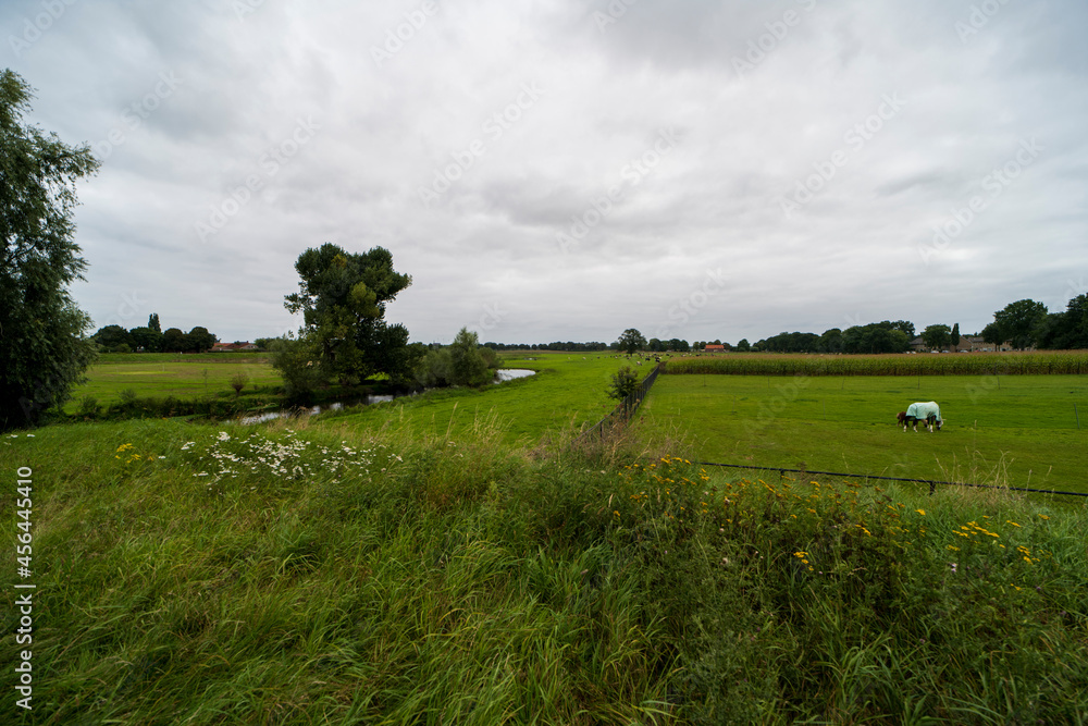 Obraz premium The Niers river with the church tower of Ottersum in the background