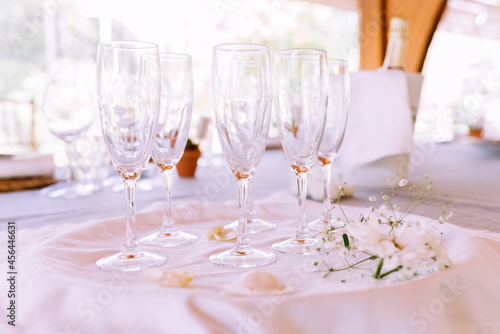Empty champagne glasses arranged on a tray before a joyous and festive celebration with alcohol.
