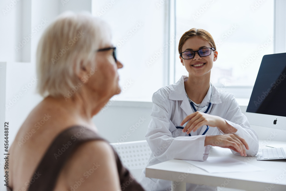 elderly woman with glasses talking to the nurse doctor assistant elderly woman with glasses talking to the nurse doctor assistant