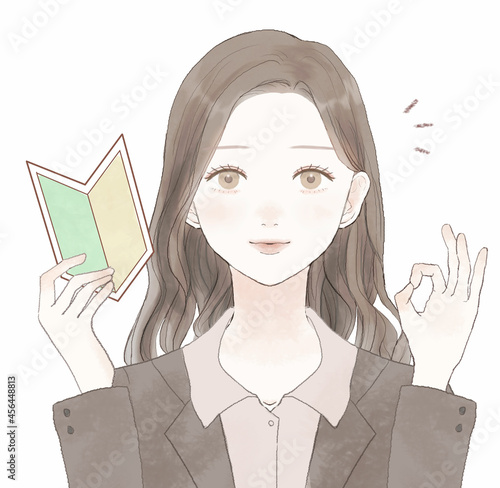 初心者マークを持ってOKサインを出す女性社員