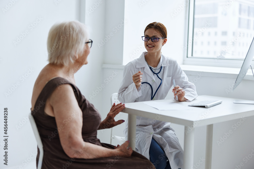 Fototapeta premium elderly woman with glasses communicates with the doctor medical office