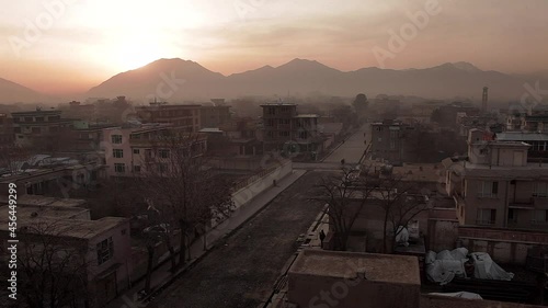 Afghanistan scene - sunrise over Kabul city - wide angle view of street and hills photo