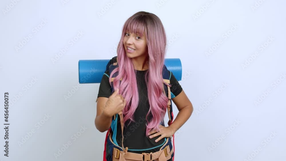 Young woman with pink hair with mountaineering backpack presenting and inviting to come with hand over isolated background Young woman with pink hair with mountaineering backpack presenting and inviting to come with hand over isolated background