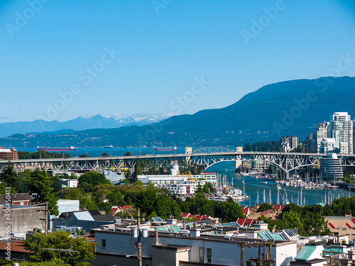 Cityscape of Vancouver looking towards the port with steel bridge over the inlet and the Mountains in the distacnce © quasarphotos