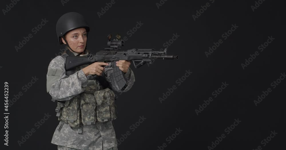 Mature female soldier with assault rifle on black background Mature female soldier with assault rifle on black background