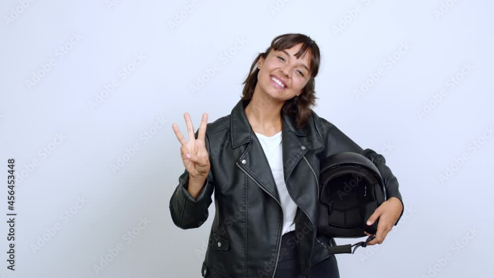 holding a motorcycle helmet happy and counting with fingers over isolated background holding a motorcycle helmet happy and counting with fingers over isolated background
