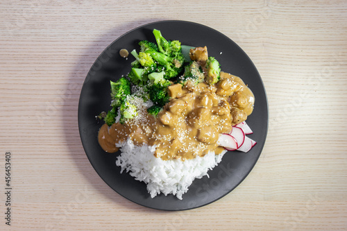 A plate of satay chicken, broccoli, and white rice. photo