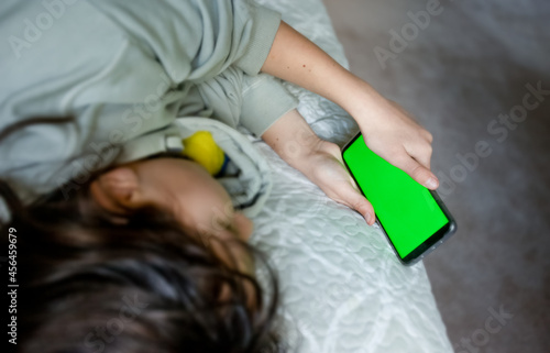 teenager girl holding phone with green screen, adolescent girl using phone, modern digital technologies