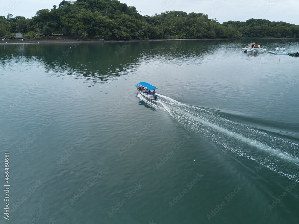 Fototapeta premium A small locally operated boat ferries locals and tourists across Cuchilla Bay to a remote part of Puntarena Province as seen from aerial drone image