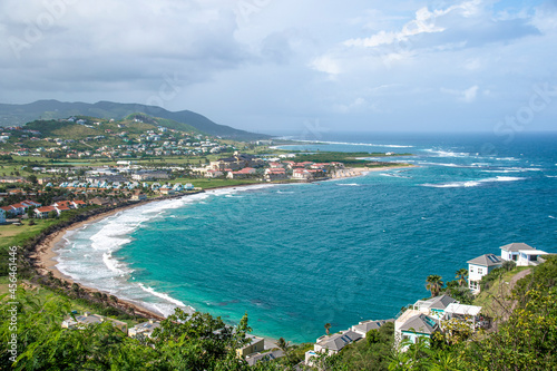 The Atlantic Ocean crashes onto a sandy beach in St. Kitts on a beautiful day in this picturesque scene from the Timothy Hill Overlook.