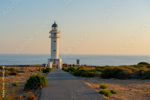 People walk down the street towards the Cap de Barbarie Lighthouse in Formentera in the summer of 2021.
