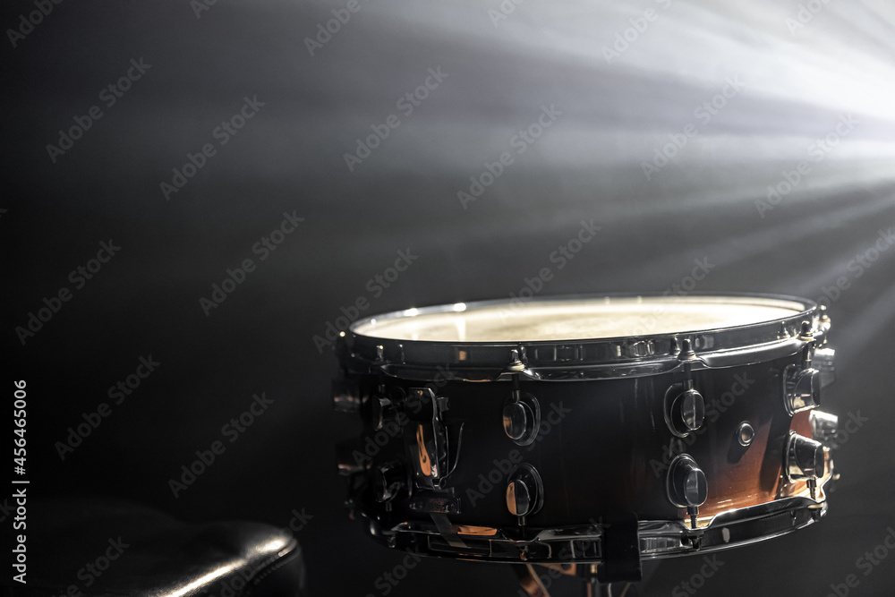 Obraz premium Snare drum on a black background with stage lighting, copy space.