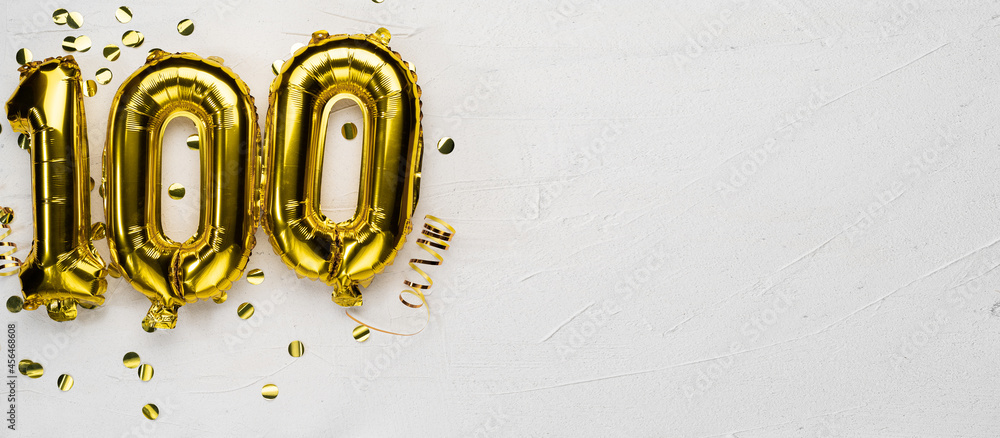 golden foil balloon number one hundred. Birthday or anniversary card with the inscription 100. gray concrete background. - obrazy, fototapety, plakaty 
