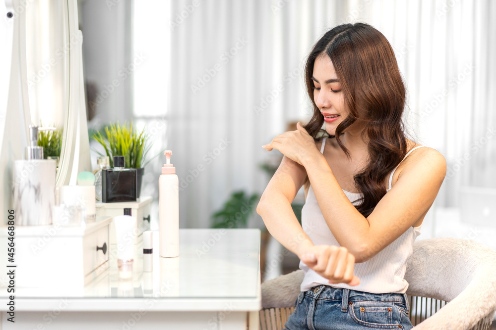 Smiling of young beautiful pretty asian woman clean fresh healthy white skin looking at mirror.Asian beauty girl touching on her hand and applying cream at home.spa and beauty concept Smiling of young beautiful pretty asian woman clean fresh healthy white skin looking at mirror.Asian beauty girl touching on her hand and applying cream at home.spa and beauty concept
