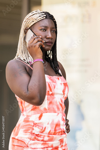 young adult african woman talking with phone outside