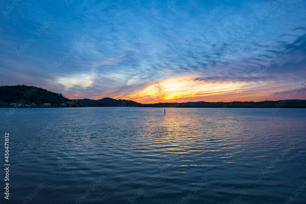 Sunrise waterscape with soft high cloud cover