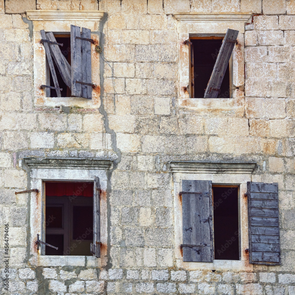 Wall with opened windows of old ruined house