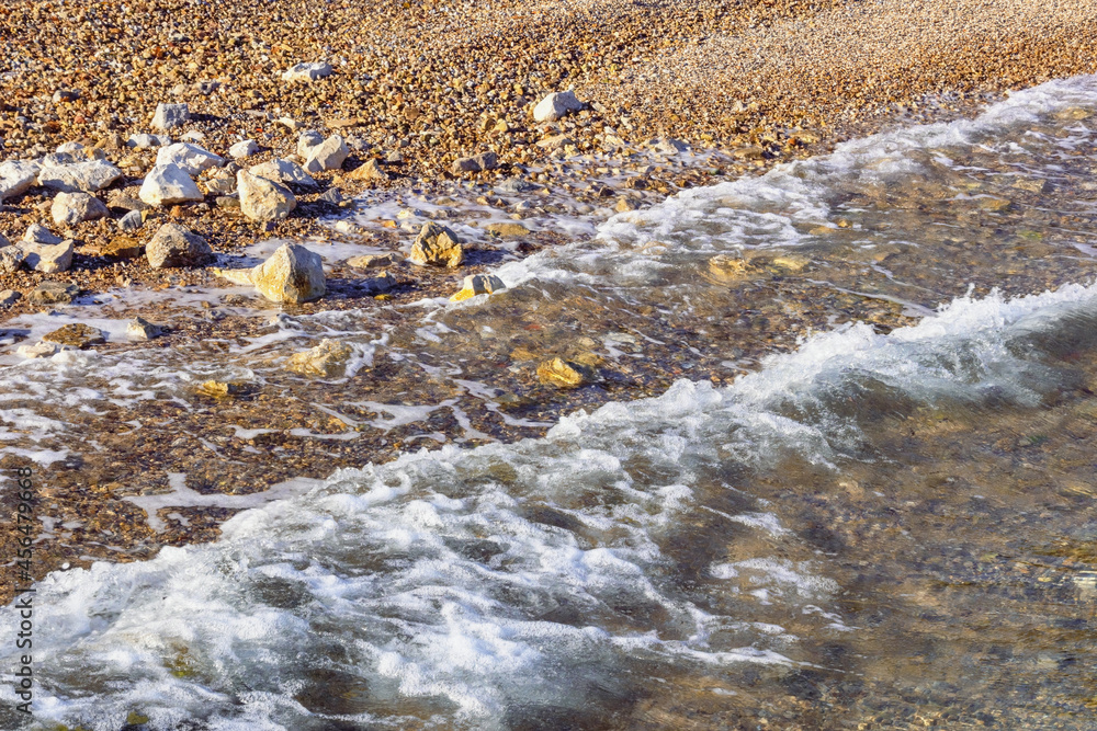 Seaside on a calm sunny day. Pebble beach of the Adriatic Sea, Montenegro Seaside on a calm sunny day. Pebble beach of the Adriatic Sea, Montenegro