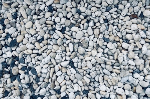 Smooth round pebbles texture background. Pebble sea beach close-up, dark wet pebble and gray dry pebble. 