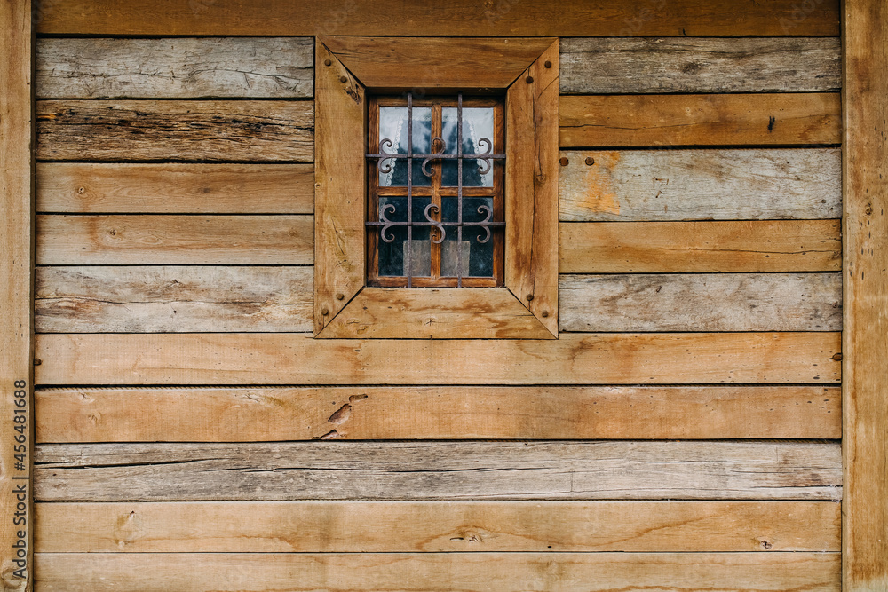 Old wooden house wall with a small window. Old wooden house wall with a small window.