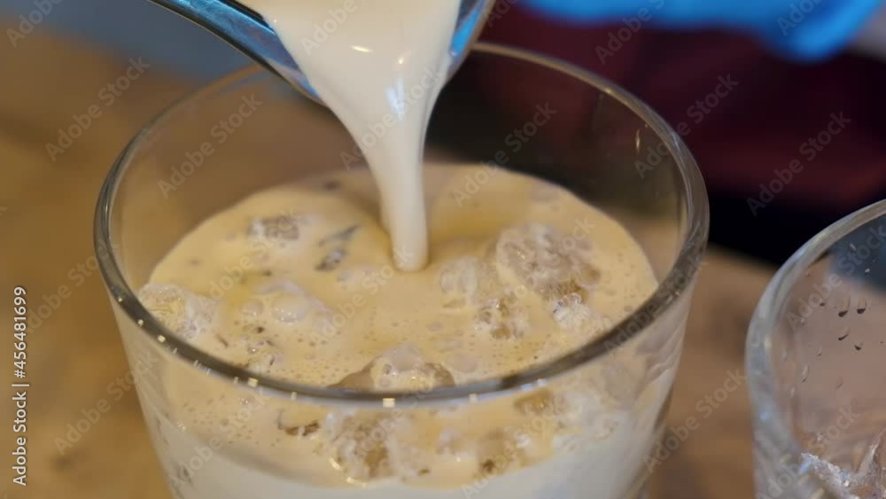 close up, A bartender in a cafe pours an alcoholic cocktail baileys