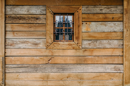Old wooden house wall with a small window.