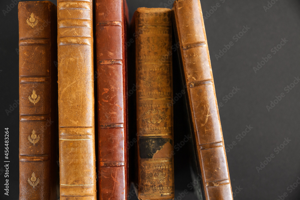 Row of old books on dark background Row of old books on dark background