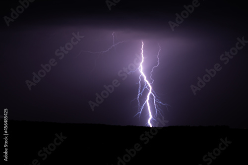 Lightning strikes painting the sky purple on a summer evening during a thunderstorm