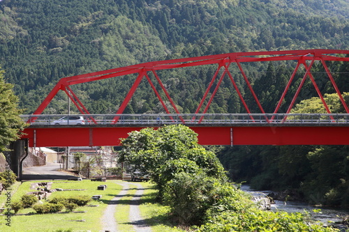 山の緑と赤の鉄橋
