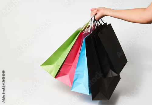 Woman hand with shopping bags on white background