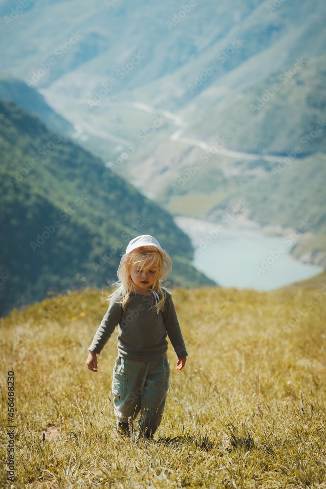 Child girl walking in mountains family vacations healthy lifestyle 2 years old kid sustainable eco tourism